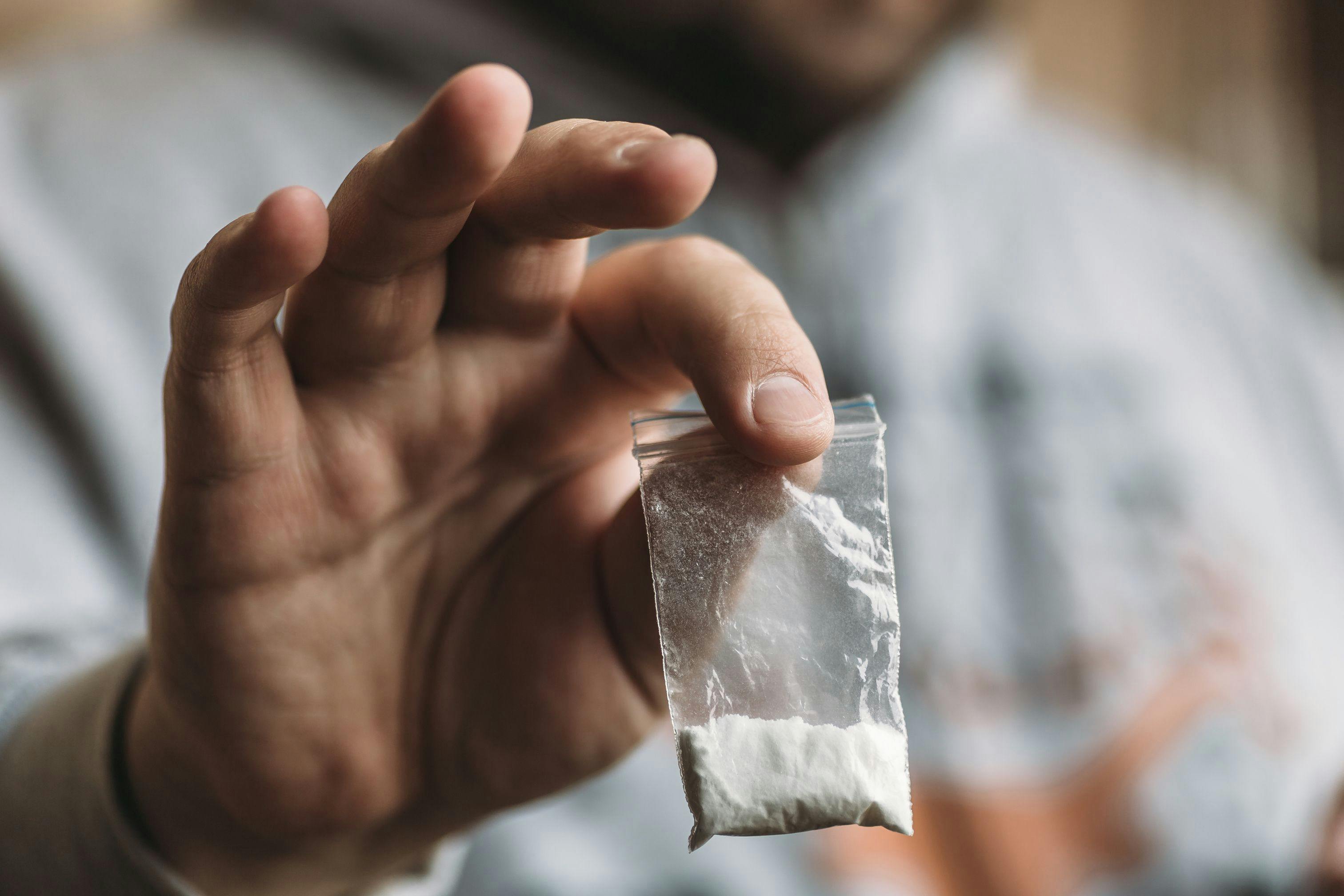 Man hand holding cocaine or other drugs, drug abuse | Image Credit: © DedMityay - stock.adobe.com