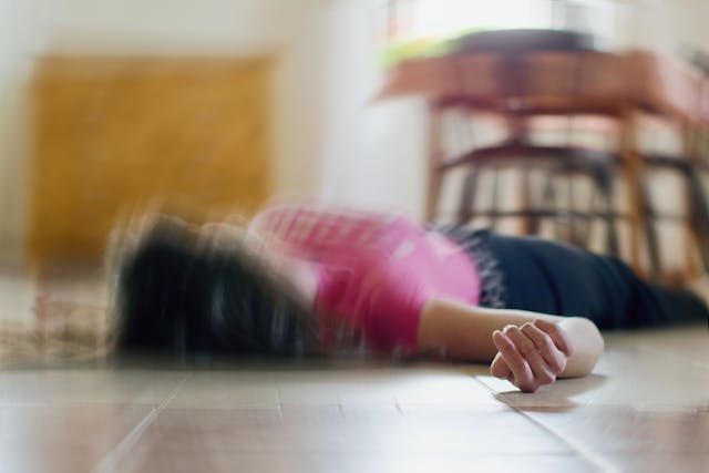 Woman lying on the floor at home, epilepsy, unconsciousness, faint, stroke, accident or other health problem. | Image Credit: © Tunatura - stock.adobe.com