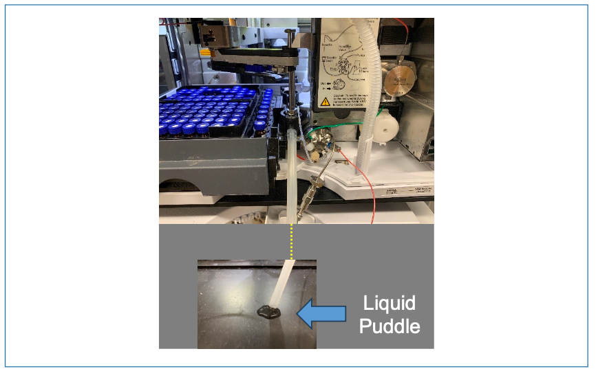 FIGURE B: Picture of the sampler in question and the puddle of liquid observed on the benchtop in front of the instrument.