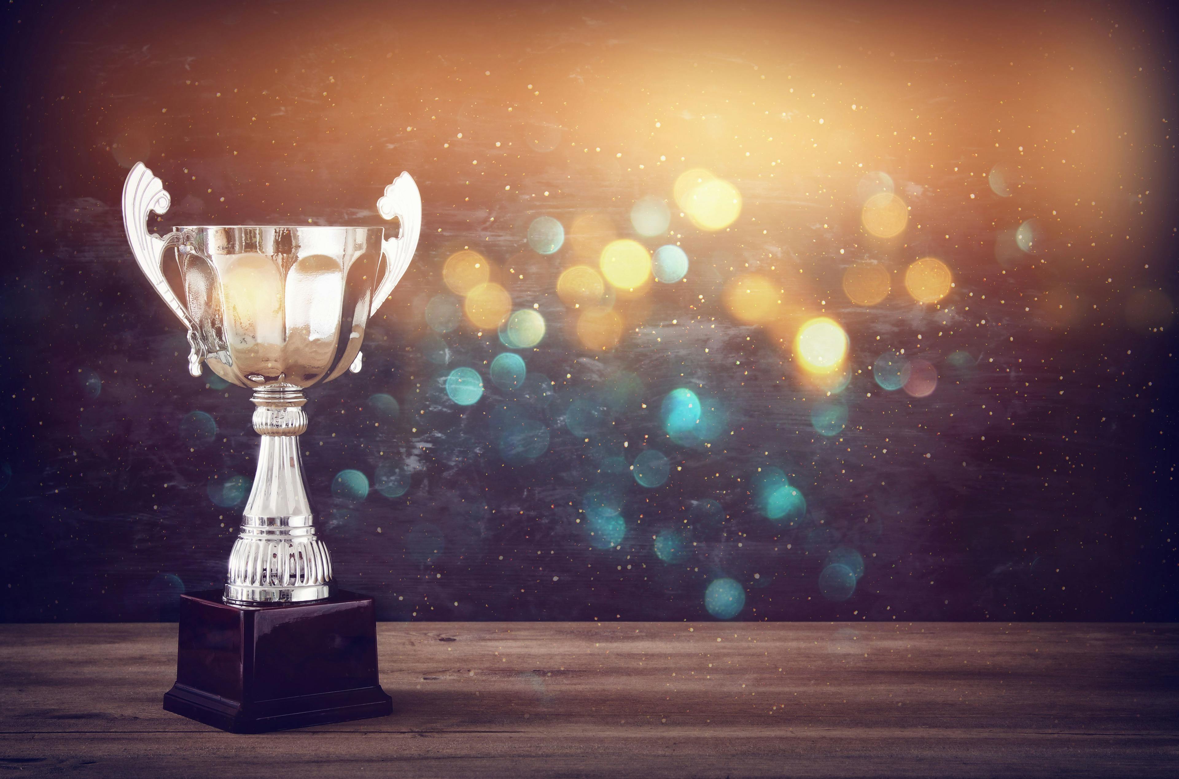 low key image of trophy over wooden table and dark background | Image Credit: © tomertu - stock.adobe.com
