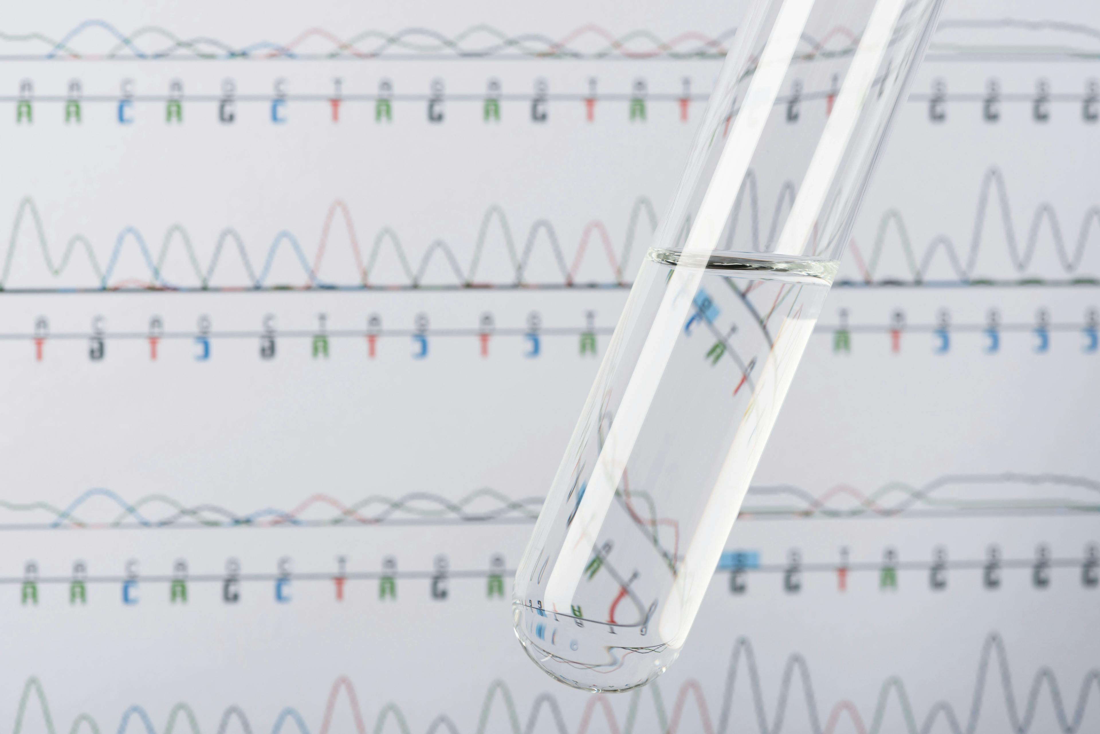 Test tube with transparent liquid and DNA chromatogram on background | Image Credit: © nevodka.com - stock.adobe.com