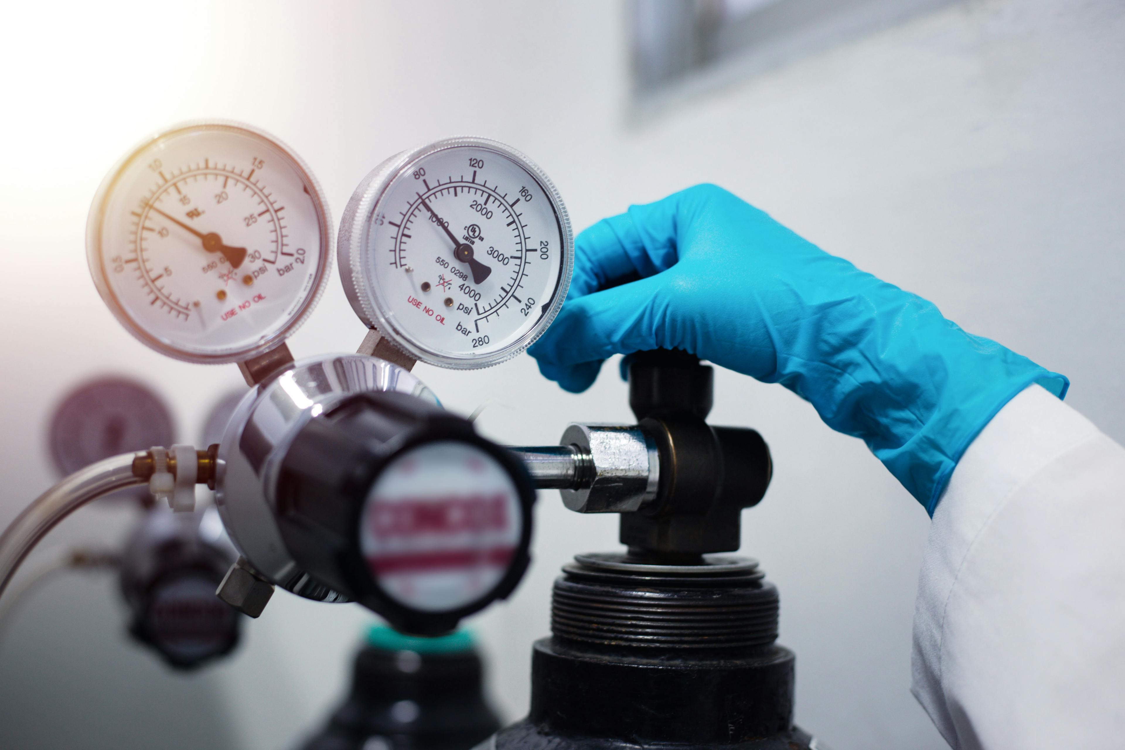 Closeup of a scientist's hand, checking gas from pressure gauge for a laboratory chromatography device during research | Image Credit: © S. Singha - stock.adobe.com