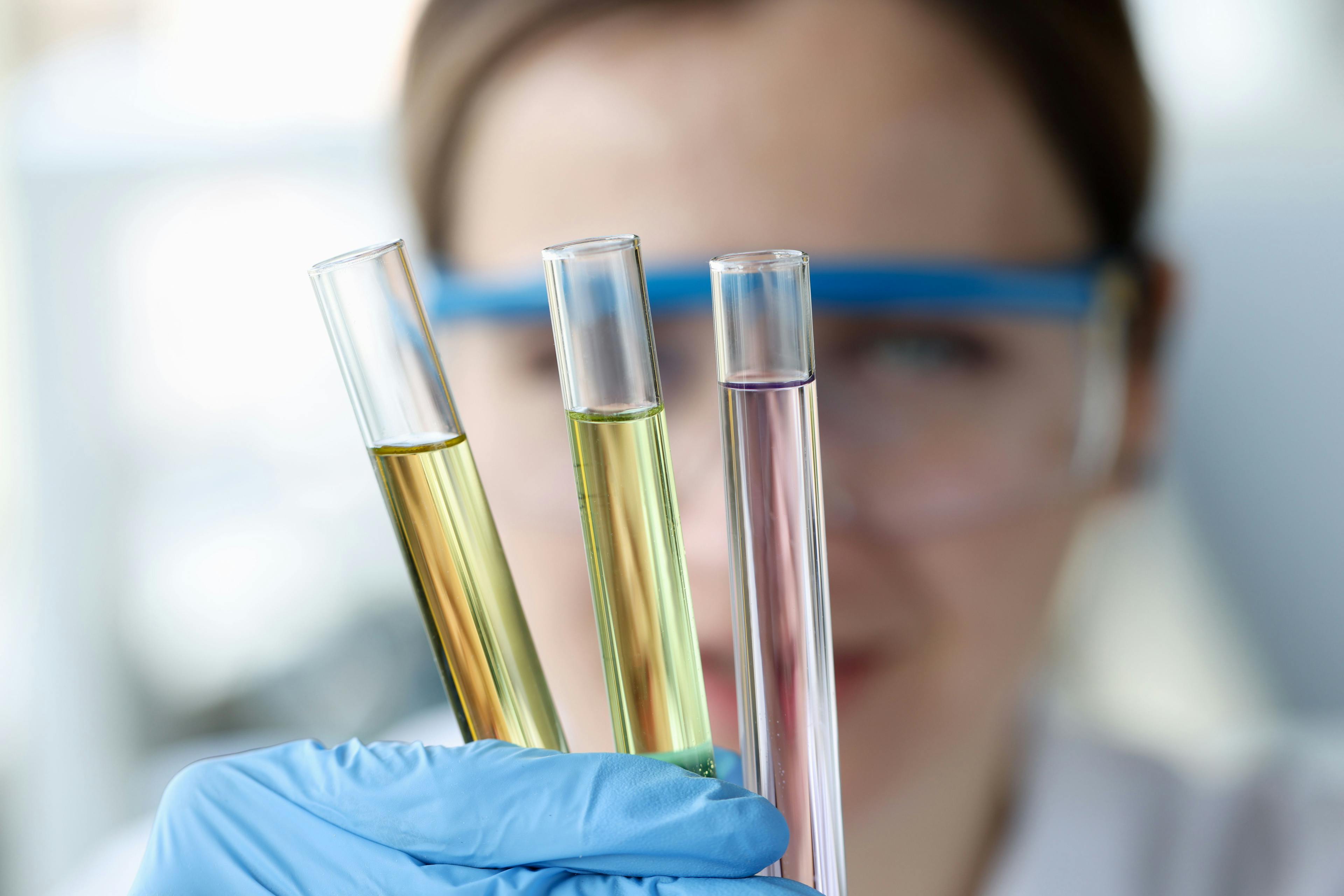 Woman scientist holding test tubes with multicolored liquids in her hands closeup | Image Credit: © megaflopp - stock.adobe.com