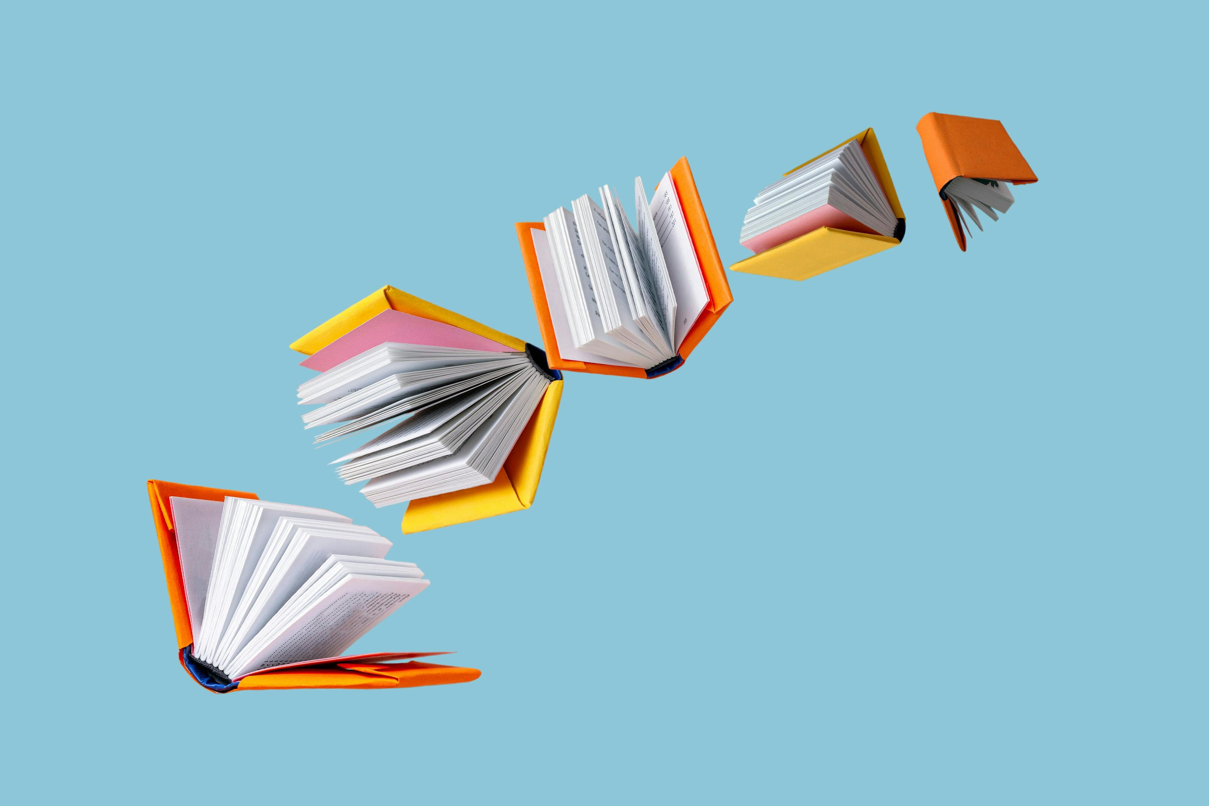 Books in colored covers swirl on a blue background, copy space | Image Credit: © Rara - stock.adobe.com