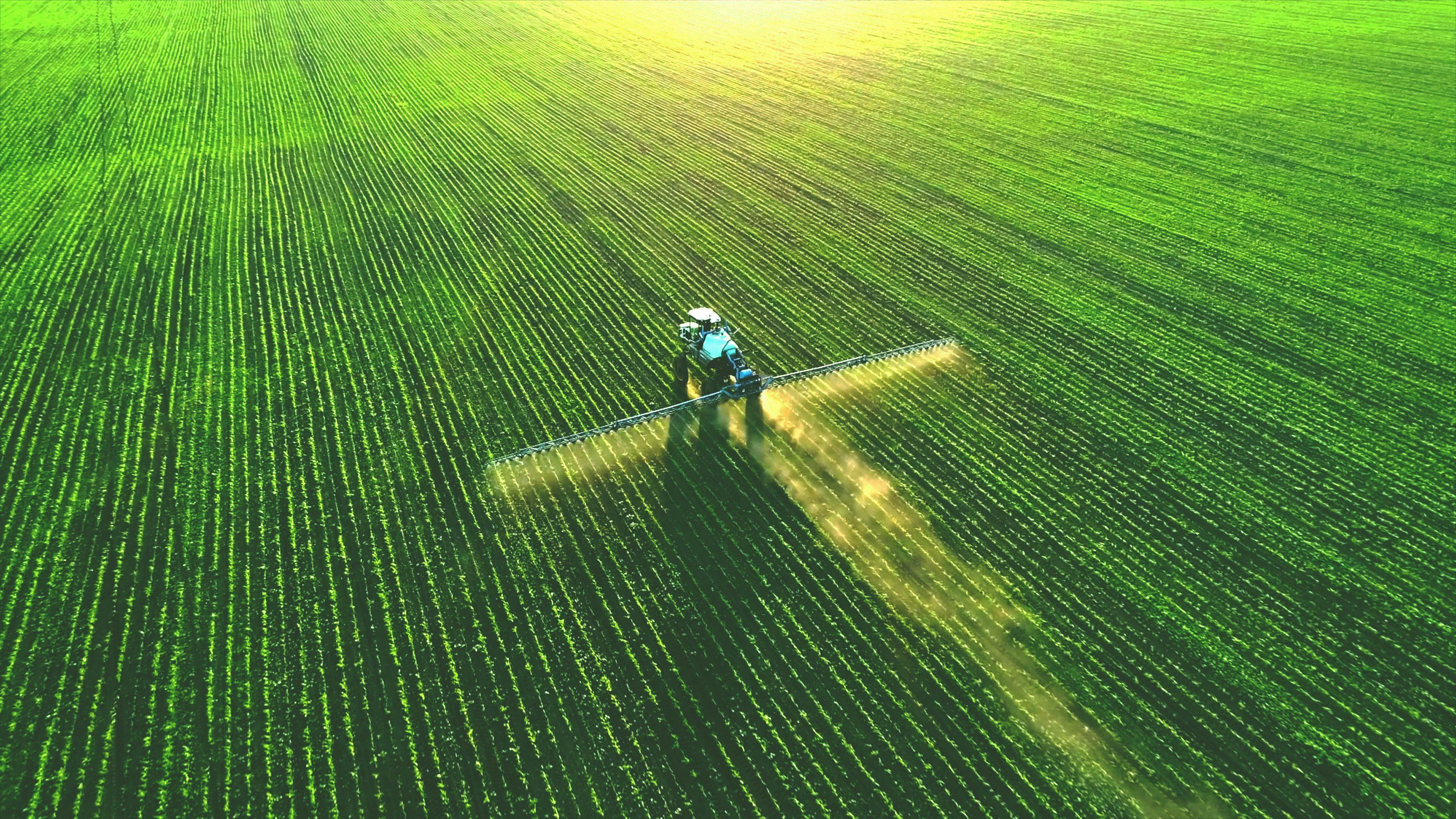 Tractor spray fertilizer on green field drone high angle view, agriculture background concept. | Image Credit: © Mose Schneider - stock.adobe.com. 