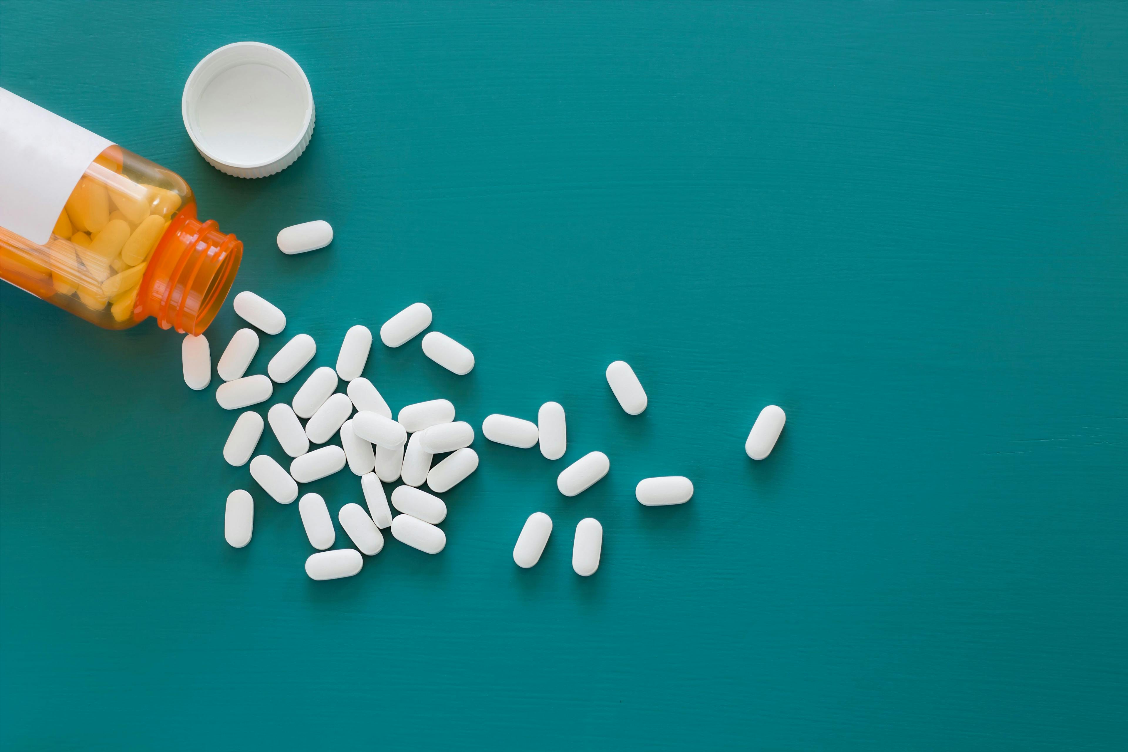 White Pills on a Teal Background | Image Credit: © SawBear Photography - stock.adobe.com.