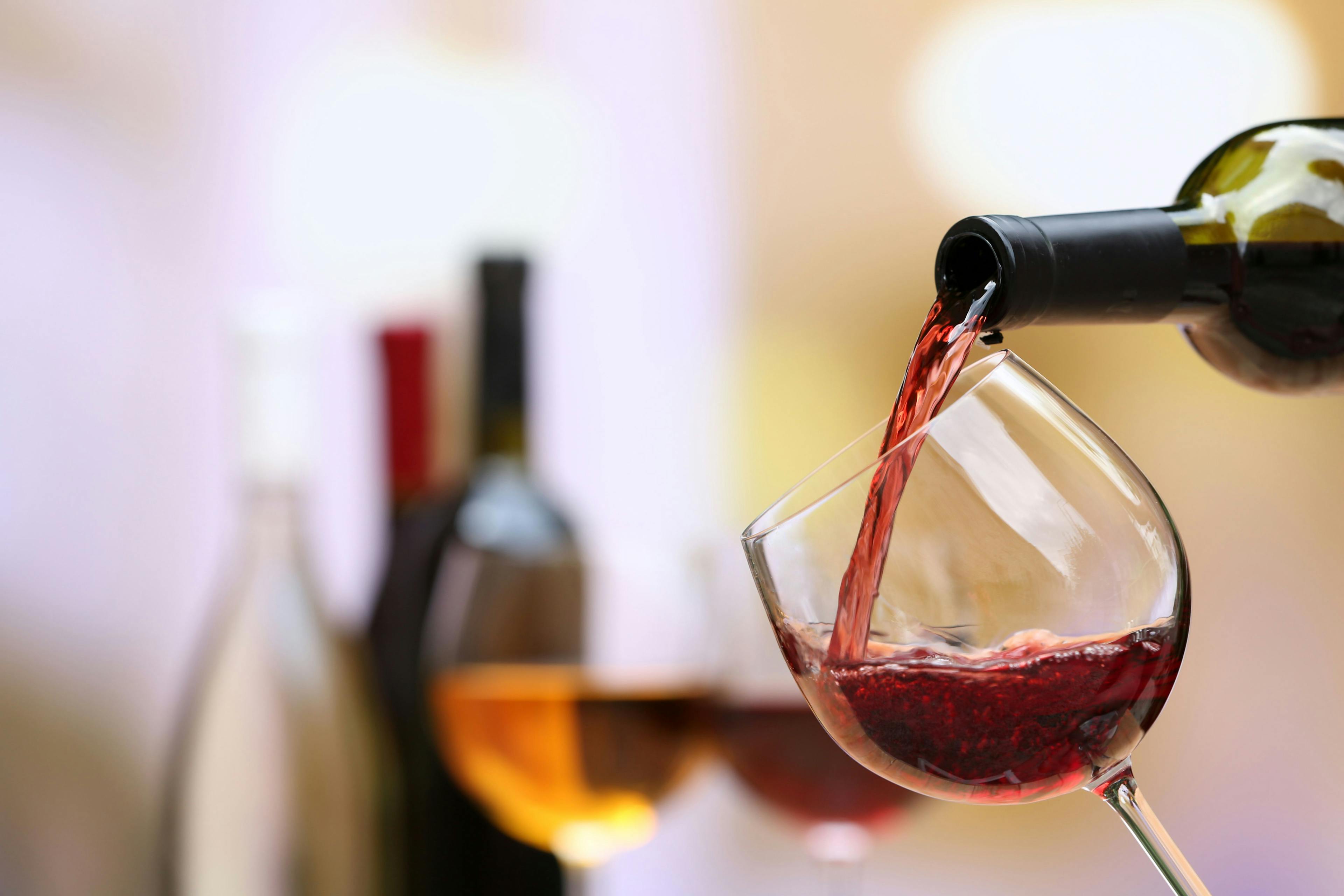 Red wine pouring into wine glass, close-up | Image Credit: © [ Africa Studio - stock.adobe.com
