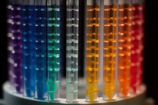 A detailed macro shot of a chromatography column packed with a rainbow of colored beads, used for separating chemical compounds | Image Credit: © aicandy - stock.adobe.com