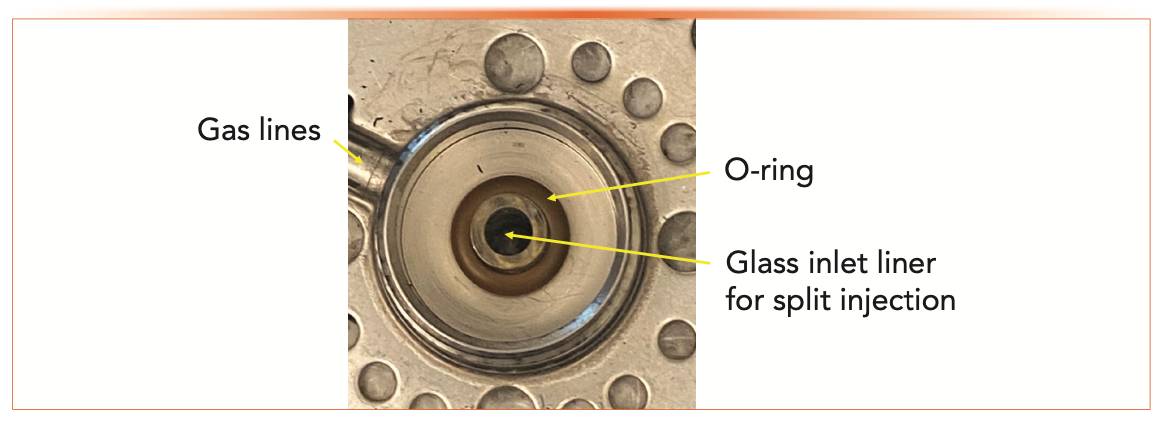 FIGURE 1: Close-up view of an inlet with the septum nut, septum, and top weldment removed showing the O-ring and glass inlet liner. The glass inlet liner has a wide inside diameter, indicating that it is for a split injection.